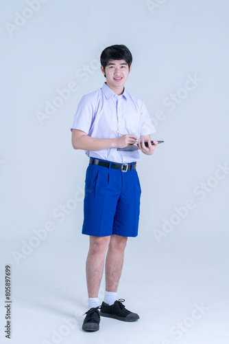Thai students with tablet. Asian boy smiles with tablet computer on isolated background.