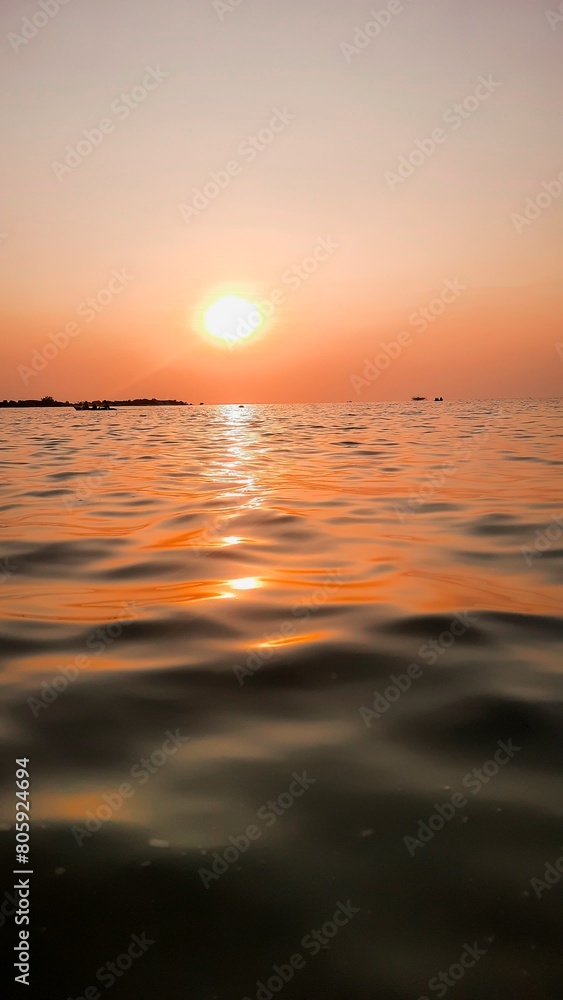 Bright sunset with yellow sun under the sea surface - Summer vacation and nature travel adventure concept. Bright sunset with yellow sun under the sea surface - Summer vacation and nature travel adventure concept.