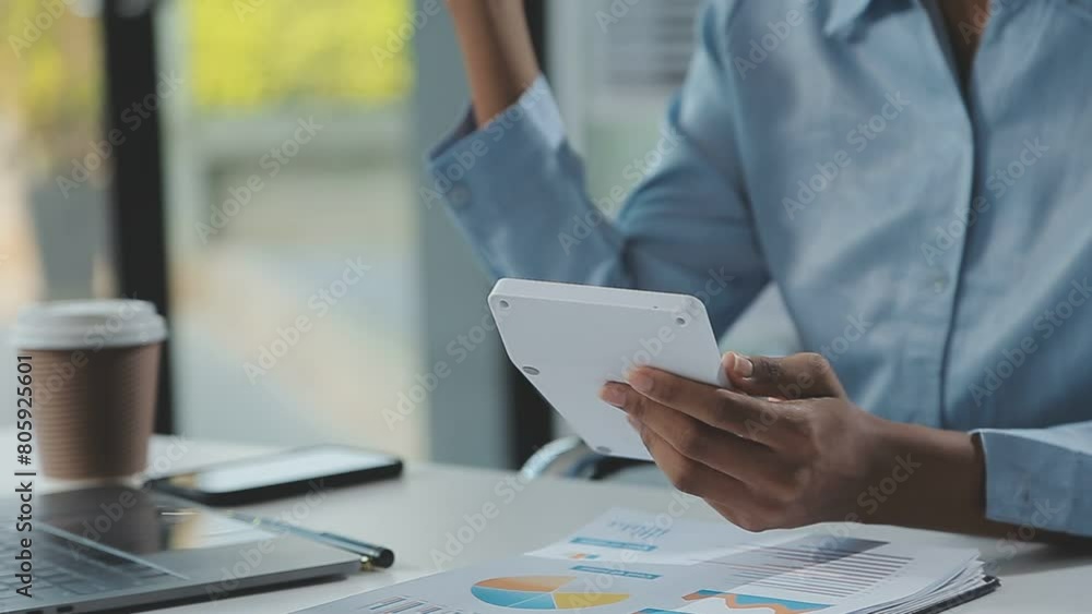 Close up Business woman using calculator and laptop for do math finance on wooden desk, tax, accounting, statistics and analytical research concept Close up Business woman using calculator and laptop for do math finance on wooden desk, tax, accounting, statistics and analytical research concept