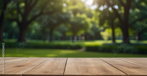 Empty wooden table top with blurred green nature garden background for product placement. Product background