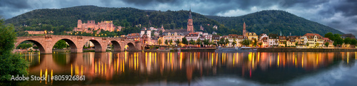 Panorama of the old town of Heidelberg, Germany, showing the "Old Bridge" and the Castle at dusk. An extra wide scenic blue hour cityscape