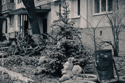 Christmas tree with toys near the house in the ruined city in Ukraine photo