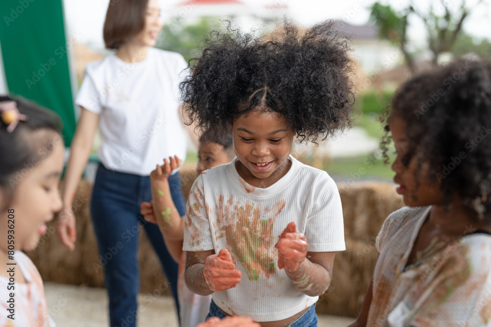 African American little girls and friends have fun hands painted in colorful paint.education concept African American little girls and friends have fun hands painted in colorful paint.education concept