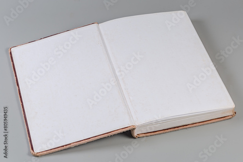 Open old book with shabby cover on a gray background