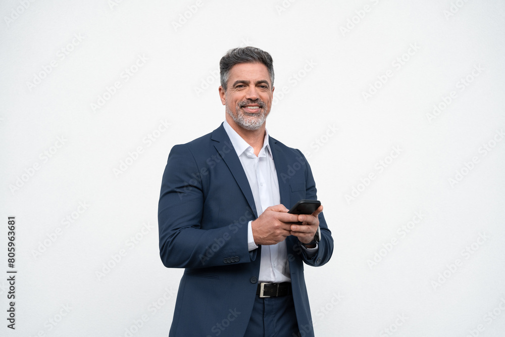 Mature businessman in suit holding cellphone isolated, white background. Smiling Latin business man using smartphone mobile phone screen device, scrolling app, working, looking at camera. Copy space Mature businessman in suit holding cellphone isolated, white background. Smiling Latin business man using smartphone mobile phone screen device, scrolling app, working, looking at camera. Copy space