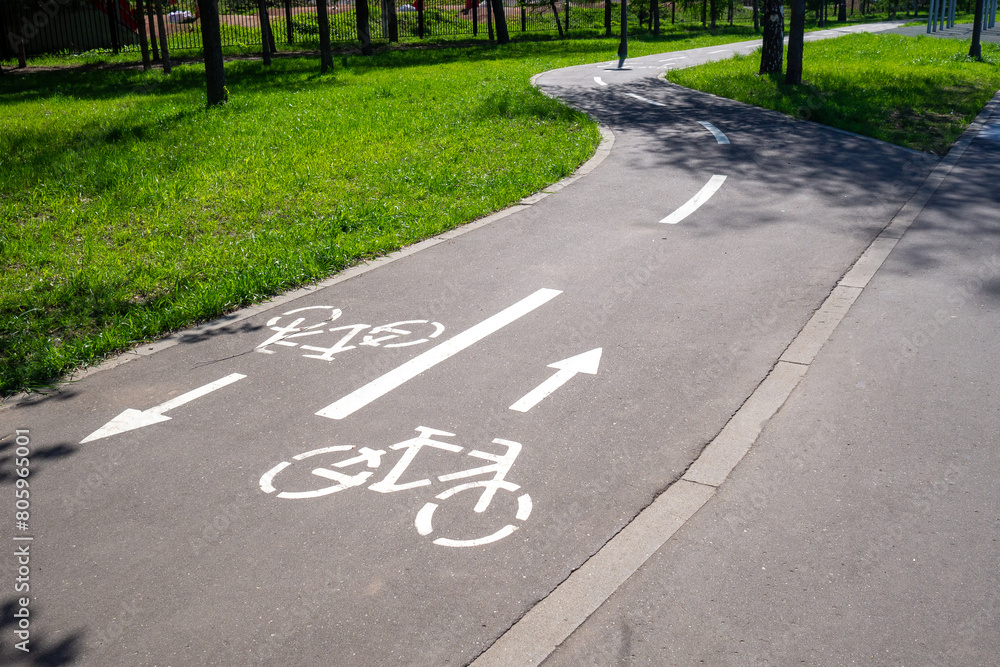 Obraz premium Winding cycleway with pictograms and directional guidance in summer park