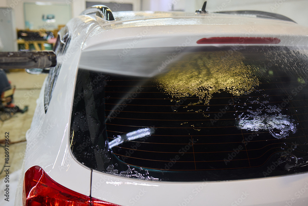 Fototapeta premium Foam covers car in garage tires, wheels, lights, hood, automotive design