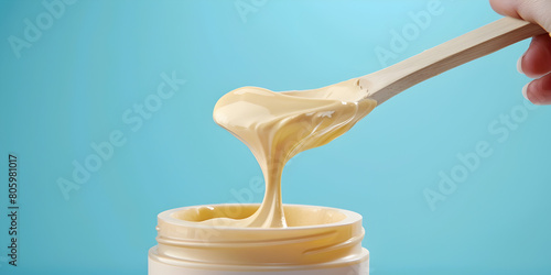 Hand Applying Wax or Sugar Paste with Wooden Spoon Hand Holding Beauty Wax on Wooden Spoon