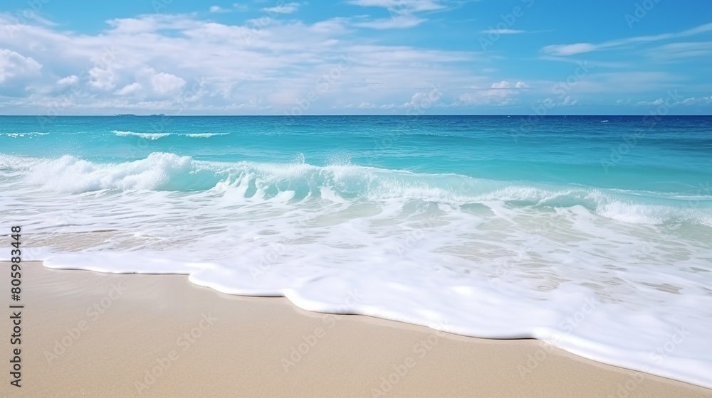 Beautiful sandy beach with gentle rolling sea waves accompanied by views of blue sky and white clouds