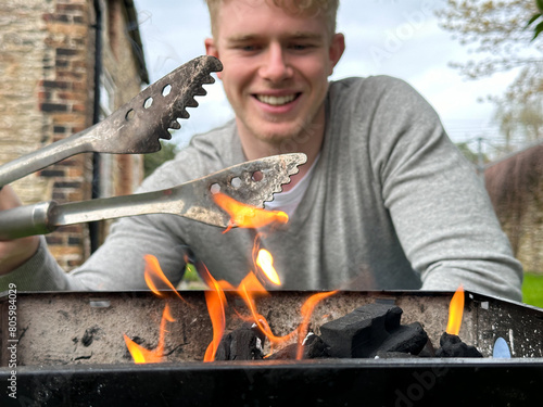 Selective focus on fire flames, cheerful handsome man smiling on background