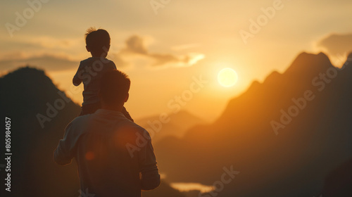silhouette of a person on the top of a mountain on Father s Day  with a silhouette of a young boy joyfully riding on his father s shoulders