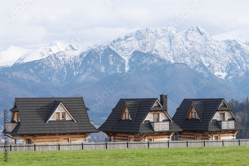 ZAKOPANE, POLAND - MAY 22, 2023: Wooden cottages for tourists with a view of the Tatra Mountains.