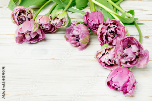 Pink tulips on wooden table.