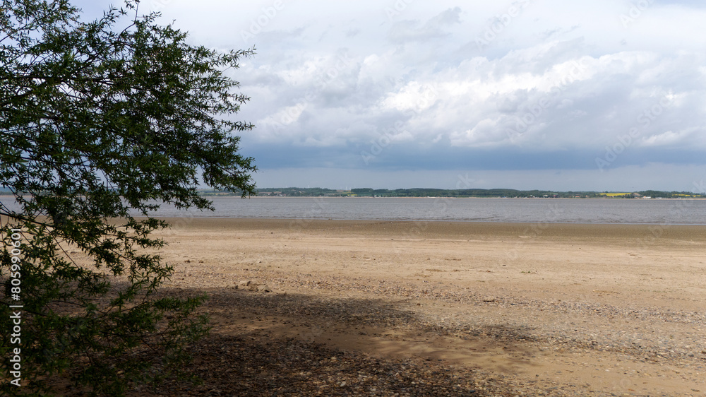 Plaża wzdłuż brzegu jeziora, zbiornika wodnego, spuszczona woda.
