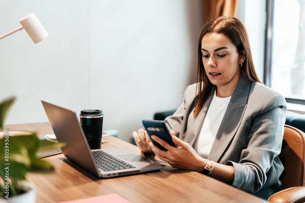 woman in the office using her smartphone woman in the office using her smartphone