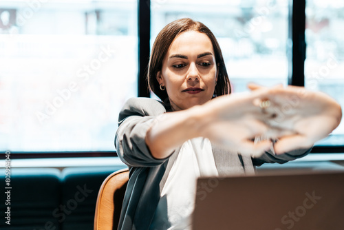 tired businesswoman sitting in front of laptop in an office