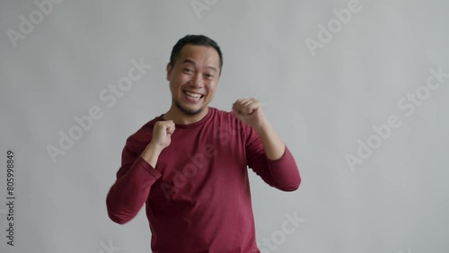 Asian Man Enjoy Dancing, Move Body Attractively Isolated On Gray Background  photo