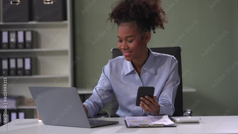 Black businesswoman sits in a office working on smartphone and tablet play social media. Black businesswoman sits in a office working on smartphone and tablet play social media.