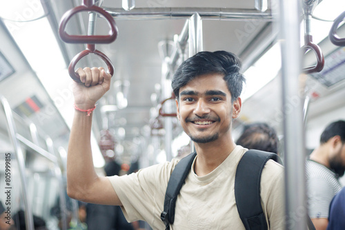 Portrait of young Indian man passenger traveling in the metro. Delhi metro and Public transportation concept.	 photo