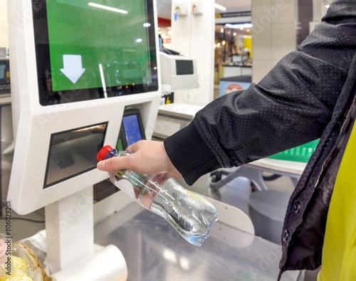 Customer pays his purchase at the supermarket,self checkout systems in retail stores,Barcode scanner,Self checkout machine