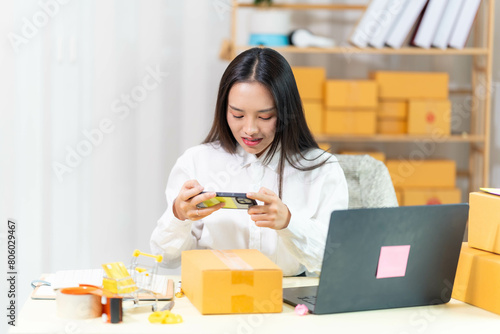  woman sit at workplace desk laughing working on-line using laptop in warehouse. 