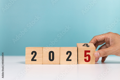 Wallpaper Mural Happy new year 2025. 2025 goal planning. Hand flip wooden cube change from the number 2024 to 2025 while at the table in the office Torontodigital.ca