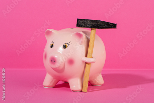 Pink piggy bank with small hammer
