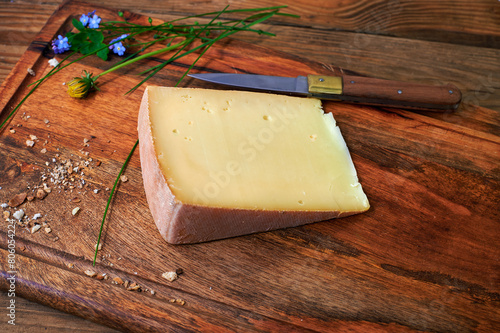 Piece of mountain cheese on a rustic wooden board