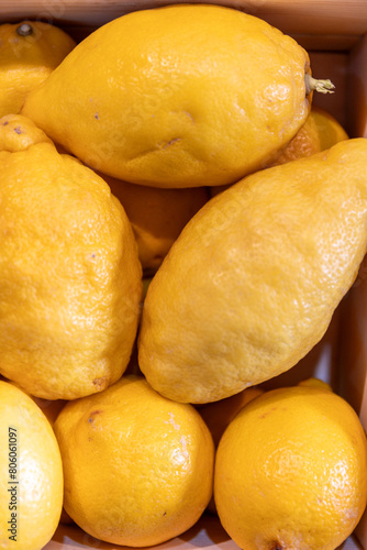 Close up shot of beautiful, healthy yellow whole italian organic lemons in a wooden box. fresh fruit market, grower's market produce.