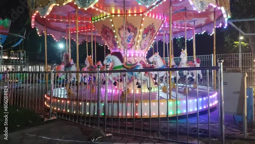 The carousel with sparkling colorful lights rotates until it stops without anyone at food junction amusement park on surabaya east java indonesia. photo