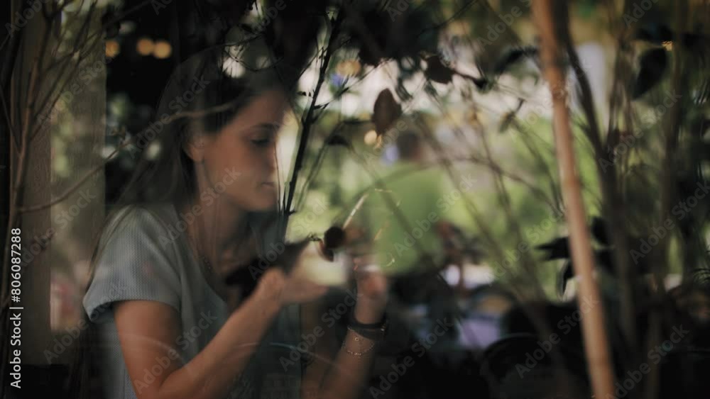 Woman looking at cellphone in cafe window Woman looking at cellphone in cafe window