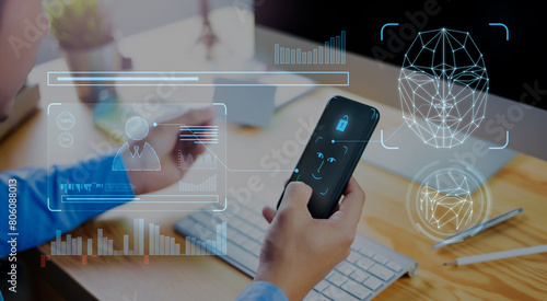 Mobile smartphone scanning  face ID to unlock phone security access with facial recognition technology for biometric identification, working at office desktop .