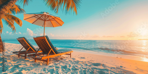 Golden hour shot of Chairs, Chaise lounge And Umbrella at White Sandy Tropical Beach with Coco Palms on the background. Summer vacation concept. Travel tourism background concept.