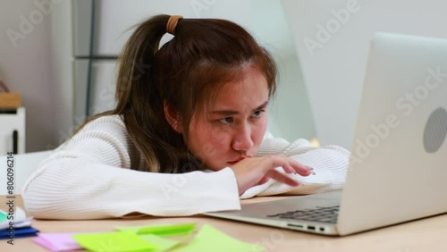 Tired exhausted, fatigue and fell asleep. Yaoung asian thai female working on laptop in kitchen room at home. Overwork. Exhausted woman  sleeply eye at workplace photo