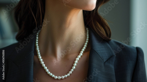 A timeless pearl necklace paired with a tailored blazer, epitomizing the sophistication and confidence of a businesswoman.