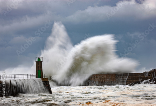 Impressive huge waves hitting the port of Viavelez in Asturias during a storm in the Cantabrian Sea photo