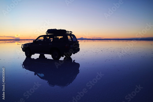 Silhouette of a Van on the Mirror Effect, a Shallow Flooding of Uyuni Salts Flats in Potosi Department of Bolivia, South America photo