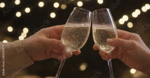 Celebratory Toast with Champagne Glasses Against a Bokeh Background with Sparkler, Symbolizing Festivity and Joy.