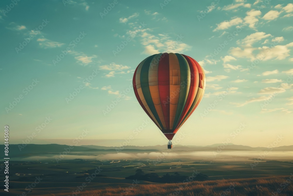 Obraz premium A hot air balloon is flying high in the sky, surrounded by a beautiful landscape