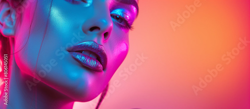 Fashion model with glowing make-up in colorful bright neon lights studio, space for text