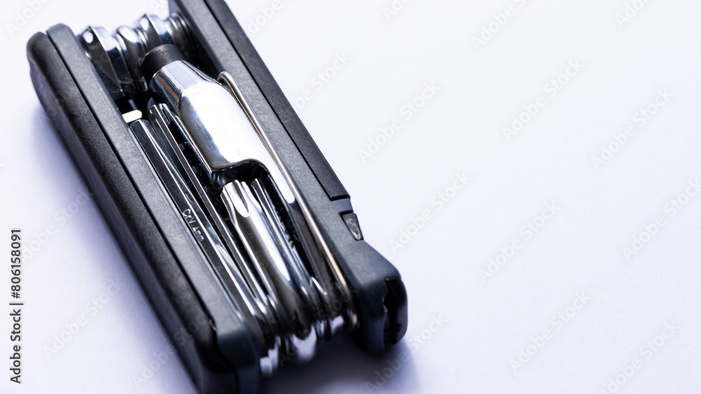 Black bicycle multifunctional multitool unfolded on a white background. Chrome steel tools. Tools for bicycle self-repairing .