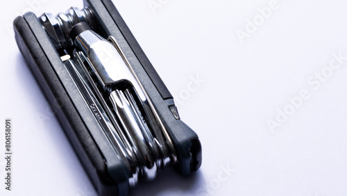 Obraz na płótnie Black bicycle multifunctional multitool unfolded on a white background. Chrome steel tools. Tools for bicycle self-repairing . w salonie