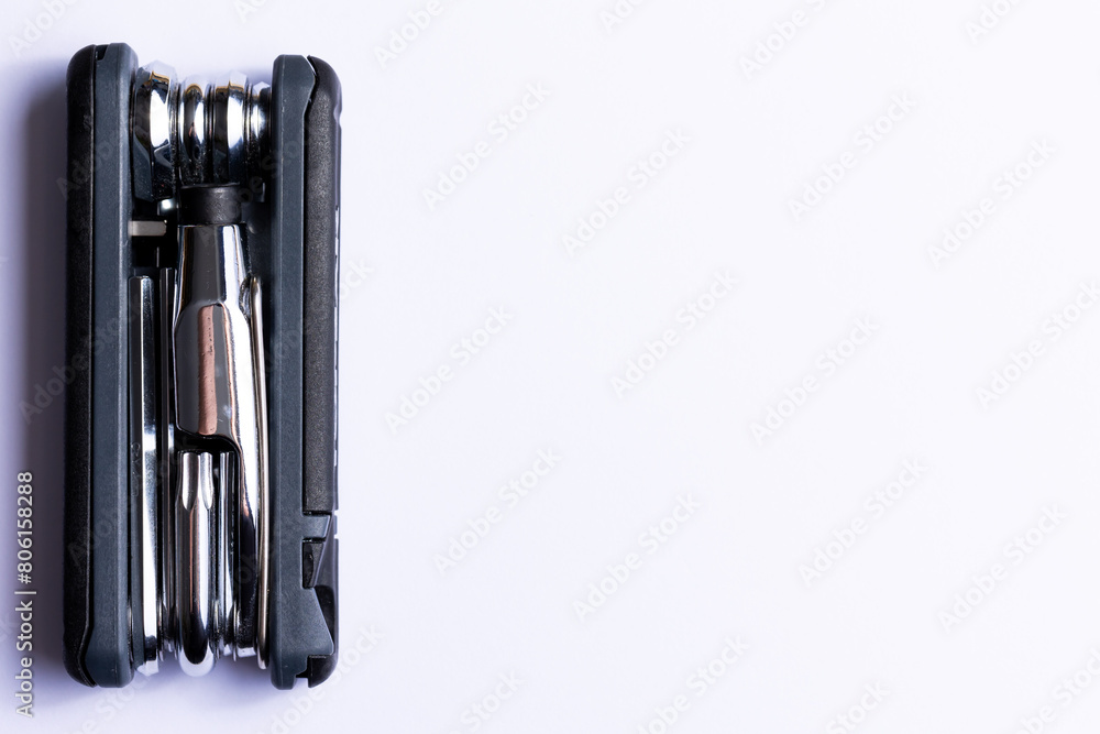 Black bicycle multifunctional multitool unfolded on a white background. Chrome steel tools. Tools for bicycle self-repairing .