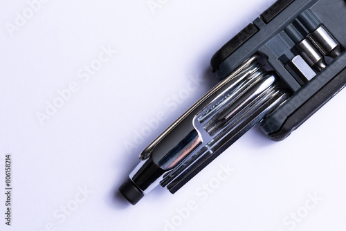Obraz na płótnie Black bicycle multifunctional multitool unfolded on a white background. Chrome steel tools. Tools for bicycle self-repairing . w salonie