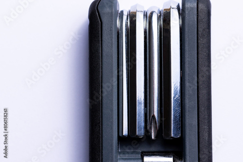 Obraz na płótnie Black bicycle multifunctional multitool unfolded on a white background. Chrome steel tools. Tools for bicycle self-repairing . w salonie