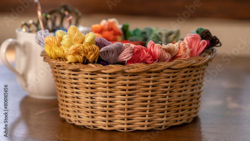 Floss Threads in Cane Basket for Eco-Friendly Crafting with Tools on Wooden Table