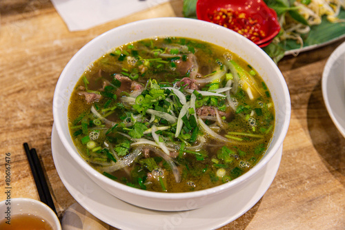 Classic Pho Bo: Vietnamese Beef Noodle Soup Served with Fresh Basil and Lime in an Aromatic Broth