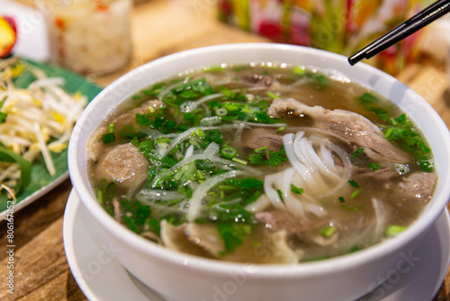 Pho Bo and Bo Vien Served Hot: A Perfect Blend of Vietnamese Noodles, Beef, and Meatballs with Fresh Herbs photo