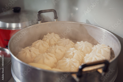 Steaming Hot Steamed Buns Fresh from the Stove, Ready to Serve in a Large Stainless Steel Steamer