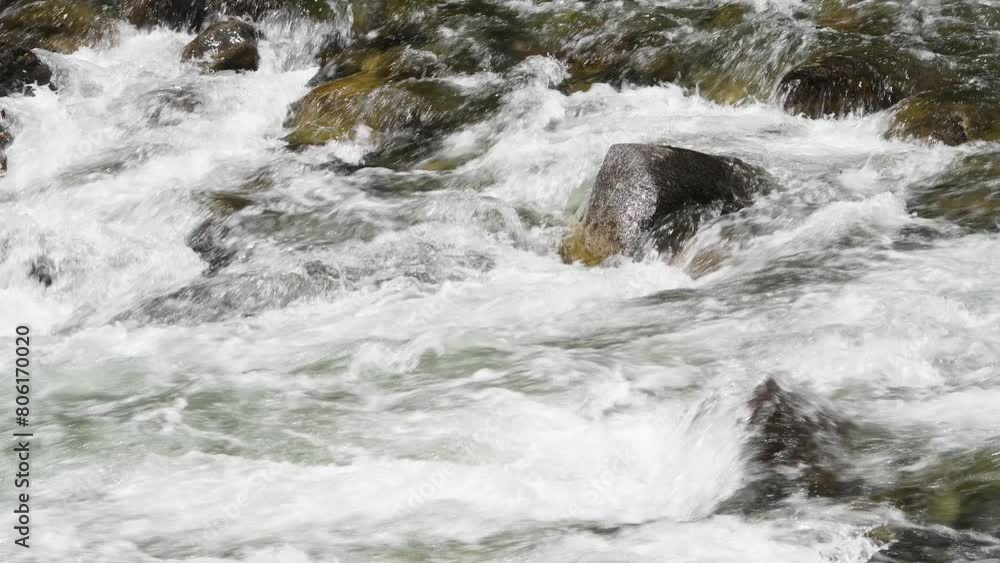 Refreshing whitewater river rushing across boulders in riverbed creating turbulent scene of moving choas as fresh water crashes over large rocky stones Refreshing whitewater river rushing across boulders in riverbed creating turbulent scene of moving choas as fresh water crashes over large rocky stones